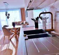 Konyha egy 3 szobás lakásban világos padlóval, fa dekorral és stílusos ülőgarnitúrával.