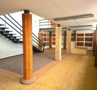 Kétszintes üzlethelyiség fa dekorációjú padlóval és lépcsővel.