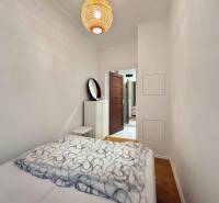 Hálószoba ággyal és fa dekorációjú padlóval egy kétszobás lakásban.