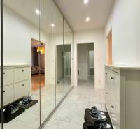 Előszoba nagy beépített szekrénnyel és cipősszekrénnyel egy 2 szobás lakásban, padlón csempével.