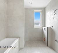 Fürdőszoba családi házban káddal, ablakkal és világos csempékkel.