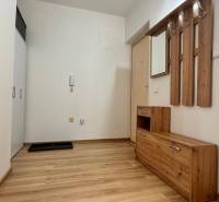 Előszoba egy kétszobás lakásban fa dekorációjú padlóval és fa bútorokkal.