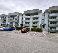 Tömbház szürke erkélyekkel a Halalovkán, Trencsénben, parkolóhelyekkel.