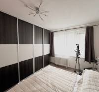 Hálószoba egy kétszobás lakásban nagy ruhásszekrénnyel és edzőfelszereléssel.