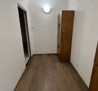 Folyosó egy 2 szobás lakásban fa dekor padlóval és bútorokkal.