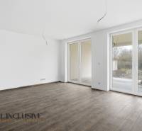 Tágas szoba egy családi házban nagy ablakokkal és fa dekorációjú padlóval.