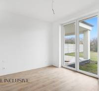 Szoba egy családi házban nagy ablakkal és fa dekorációjú padlóval.