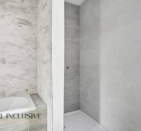 Fürdőszoba családi házban káddal és zuhanyzóval, világos csempékkel.