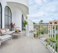 Tágas erkély a villában kényelmes ülőhellyel, növényekkel és kilátással Berawára Cangguban.