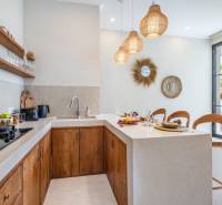 Egy villa belső tere konyhasarokkal, fa szekrényekkel és dekoratív tükrökkel.