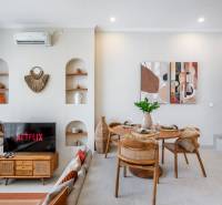 A villa nappalija TV-vel, étkezőasztallal és dekorációs elemekkel a falakon.