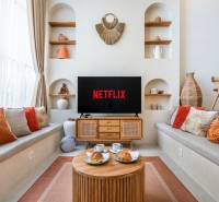 Kényelmes nappali a villában, televízióval, párnákkal és dekorációkkal, kávét szolgálnak fel.