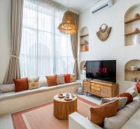 Vilabeli világos nappali kanapéval, TV-vel és dekoratív világítással.