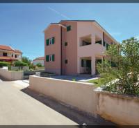 Kétszobás lakás a Privlaka utcában, Privlakában, zöld bokrokkal és szomszédos házakkal körülvéve.