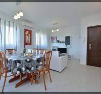 Étkezőasztal székekkel egy kétszobás lakásban, világos helyiség, fa dekoros padló.