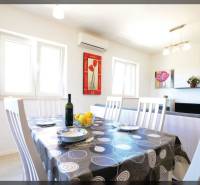 Étkező sarok egy kétszobás lakásban, megterített asztallal és faldekorációkkal.