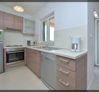 Konyha egy kétszobás lakásban, fa dekorációjú berendezéssel és padlóval.