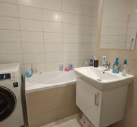 Fürdőszoba káddal, mosógéppel és mosdóval egy kétszobás lakásban.