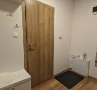 Bejárati folyosó egy kétszobás lakásban, fa dekoros padlóval és praktikus fogasokkal.