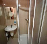 Zuhanykabin és mosdó a bérbe adott irodák fürdőszobájában.