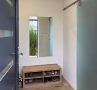 3 szobás lakás cipőpadkával, tükörrel és fa dekorációjú padlóval.