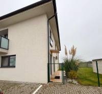 A Kráľovianky utcában található 3 szobás lakás külső része Kráľovianky városában, a bejáratnál növények és gyep.