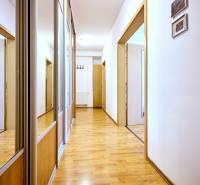 Folyosó fa dekor padlóval és beépített szekrényekkel egy kétszobás lakásban.