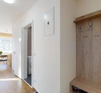 Folyosó fa mintázatú padlóval és fogassal egy kétszobás lakásban.