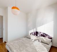 Kétszobás lakás hálószobája ággyal és fa dekorációjú padlóval.