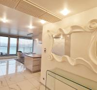 Luxusos belső tér háromszobás lakásban nagy ablakokkal és stílusos tükörrel.