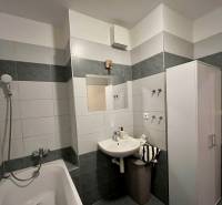 Fürdőszoba egy kétszobás lakásban káddal és mosdóval tükörrel.