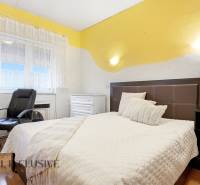 Hálószoba családi házban ággyal, székkel és fa dekoros padlóval.