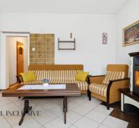 Nappali egy családi házban kandallóval, csíkos kanapéval és dohányzóasztallal.