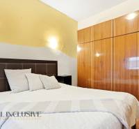 Hálószoba ággyal és beépített szekrénnyel, családi ház. Semleges színek, fa dekorációjú padló.