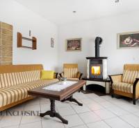 Nappali egy családi házban kandallóval, kanapéval és faasztallal.