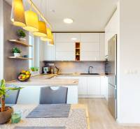 Konyha egy háromszobás lakásban, fa dekor padlóval, világítótestekkel és szobanövényekkel.