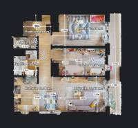 3 szobás lakás alaprajza konyhával és nappalival, fa mintázatú padlóval.