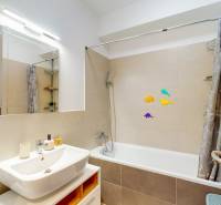 Fürdőszoba egy háromszobás lakásban káddal, tükörrel és dekoratív matricákkal.