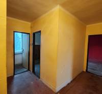 Folyosó három szobával egy kétszobás lakásban, fa dekor padlóval.