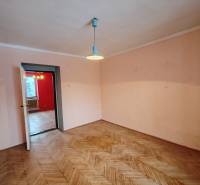 Szoba egy kétszobás lakásban, fa dekorú padlóval és egyszerű világítással.