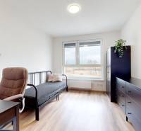 Szoba fa mintázatú padlóval, íróasztallal és kanapéval egy háromszobás lakásban.