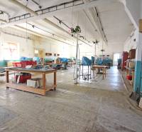 Az épület belső tere nagy csarnokkal, munkaasztalokkal és polcokkal.