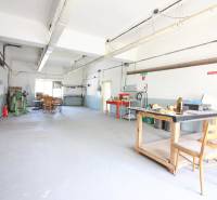 Ipari belső tér épületben, munkaasztallal és székekkel.