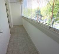 Üvegezett lodzsa terrakotta padlóval, árnyékolókkal és kilátással, amely alkalmas egy 3 szobás lakás számára.