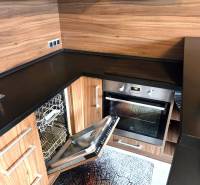 Konyha egy egyszobás lakásban beépített mosogatógéppel és fa dekorációval.