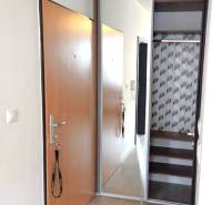 Előszoba egy egyszobás lakásban tolóajtókkal és beépített szekrénnyel.