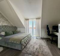 Hálószoba egy kétszobás lakásban franciaággyal, íróasztallal és fa dekorációjú padlóval.