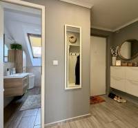 Előszoba fa dekor padlóval, tükörrel és fürdőszobával egy kétszobás lakásban.