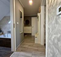 Fürdőszoba egy kétszobás lakásban, fa dekoros padlóval és világos falakkal.