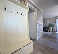 Előszoba egy kétszobás lakásban fogasokkal, amely a nappaliba vezet növényekkel.